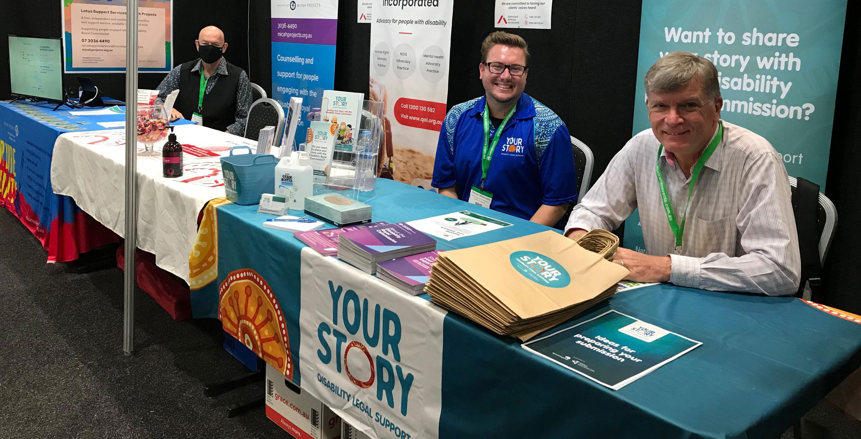 Friendly people at a table with Your Story brochures