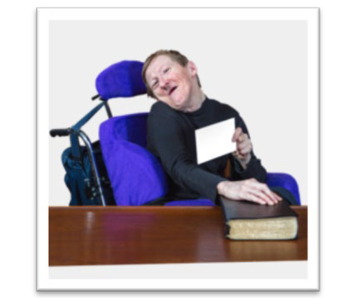 Man with disability in power wheelchair with hand on bible holding a flash card