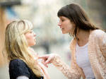 one woman with her pointer finger on the other woman's chest