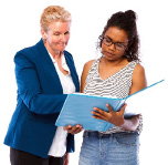 two woman looking at a book together