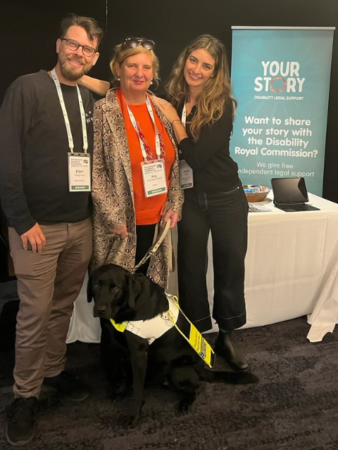 Three happy people and a guide dog