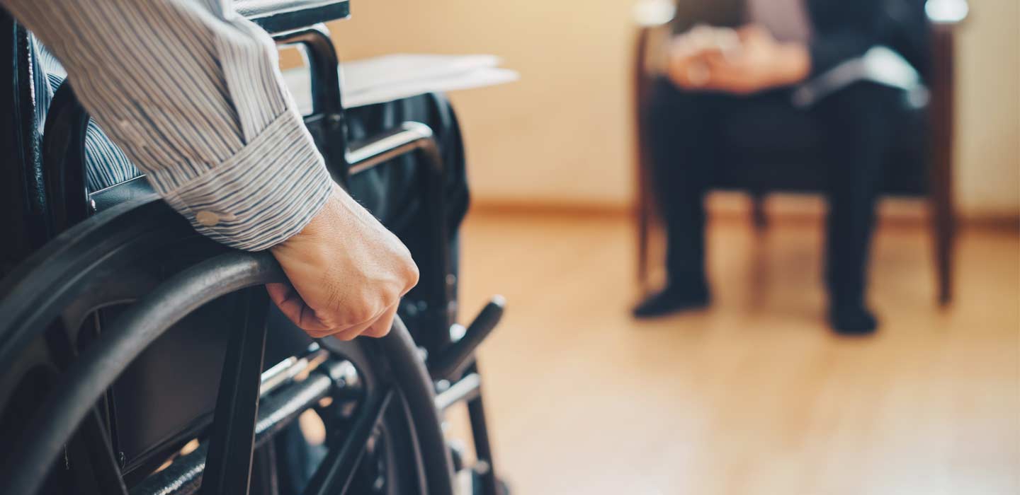 Robert in his wheelchair with lawyer in background